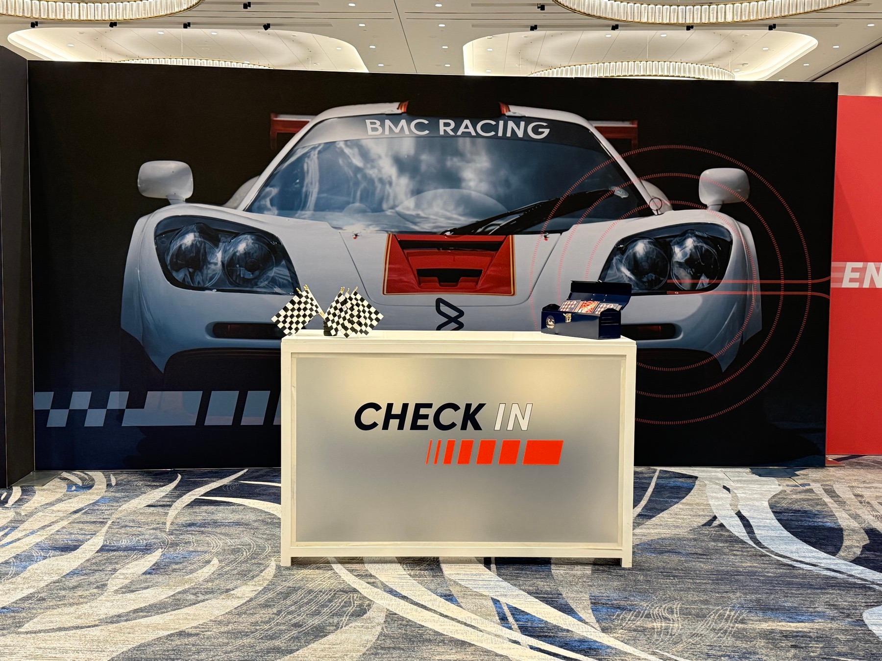 Large illuminated graphic wall behind an event check-in desk